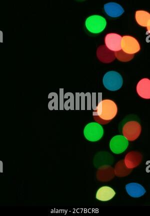 Vertical Image of Abstract Blurred Colorful Illuminated Decorating Light on Black Background Stock Photo