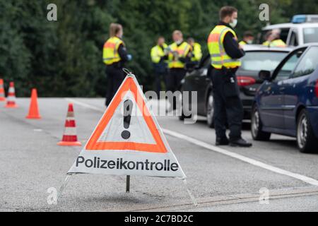 Bautzen, Germany. 16th July, 2020. A warning triangle with the inscription 'police control' is on the motorway parking lot 'Löbauer Wasser' at the motorway 4, behind it are policemen during a control mission of the police headquarters Görlitz. The control is intended to fight cross-border crime on the German-Polish border. Credit: Sebastian Kahnert/dpa-Zentralbild/dpa/Alamy Live News Stock Photo