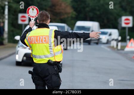 Bautzen, Germany. 16th July, 2020. A policeman is standing with a signalling trowel in the motorway parking lot 'Löbauer Wasser' at the motorway 4 as part of a control mission of the Görlitz police directorate. The control is intended to fight cross-border crime at the German-Polish border. Credit: Sebastian Kahnert/dpa-Zentralbild/dpa/Alamy Live News Stock Photo