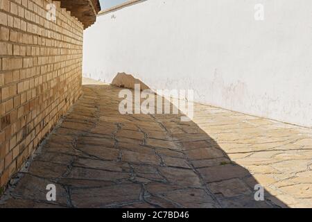 Ancient street background with adobe material walls and paving stones. Near East or central asian rural old country. Stock Photo