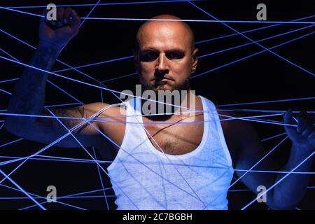 Photo of bald man tangled in white threads Stock Photo