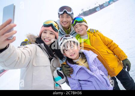 Skiing on a family of four hug together Stock Photo