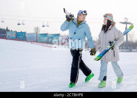 Young couples walking hand in hand with equipment in the ski resort Stock Photo