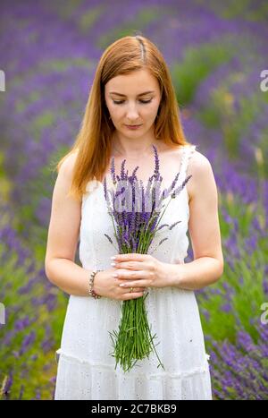 Woman walks with bouquet in lavander field, Czech republic Stock Photo