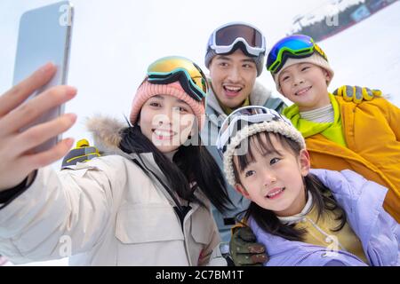 Skiing on a family of four hug together Stock Photo