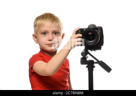 Blond boy shoots video on DSLR camera. Front view. White background, isolate Stock Photo