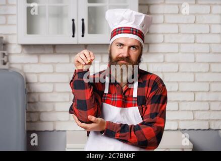 Chef sprinkling spices on dish in commercial kitchen. Stock Photo
