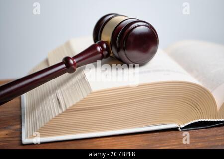 The judge hammer is next to the abstract book of the law Stock Photo