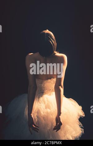 Young beautiful ballet dancer is posing in studio, view back. Stock Photo