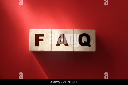 FAQ text on wooden cubes on red. Frequently Asked Questions. Business concept Stock Photo