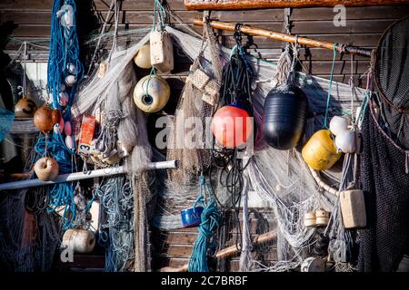 23 May 2020, Mecklenburg-Western Pomerania, Gager: All kinds of fishing gear, nets, rubber boots and buoys are hanging from one of the wood sheds of the Mönchgut fishing cooperative in the port of Gager on the Mönchgut peninsula. The Mönchgut nature reserve on the island of Rügen is one of the most scenic areas on the island. Photo: Jens Büttner/dpa-Zentralbild/ZB Stock Photo
