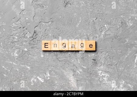 ENGAGE word written on wood block. ENGAGE text on cement table for your desing, concept. Stock Photo