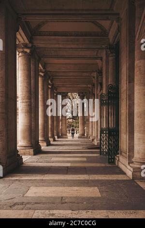 Vertical shot of a male walking along the pathway in a brown concrete building Stock Photo