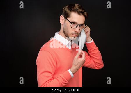 Serious young bearded man in eyeglasses wearing cloth mask to protect himself against coronavirus infection Stock Photo