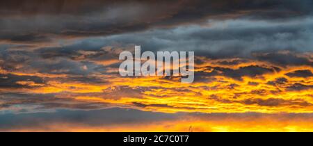 Clouds in the burning orange sky at sunset, Italy Stock Photo