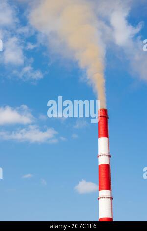 Industrial chimneys smoke smog on blue sky. Air pollution disaster concept. Day of the Planet Earth. Vertical frame Stock Photo
