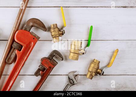 Brass gate valve on wooden background, monkey wrench brass plumbing fittings Stock Photo