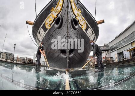 EDITORS NOTE IMAGE TAKEN WITH FISHEYE LENS Technical services staff clean the surface of the glass sea, which is a series of glass plates surrounding Brunell's SS Great Britain and filled with water to create a sea effect, as the attraction reopens on Saturday, July 18, marking the 50th anniversary of the ship’s return back home to Bristol, after the lifting of further coronavirus lockdown restrictions in England. Stock Photo