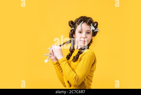 foil hair-curling trick. kid hairdresser salon. healthy long hairstyle. hair care for child. little woman grooming. beauty and fashion. small girl has foil hair curlers. Remove all the foil packets. Stock Photo