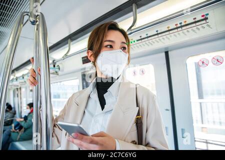 Wearing a mask of the young woman standing in the subway Stock Photo