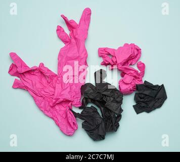 black and pink latex gloves on a blue background, recyclable trash, top view Stock Photo