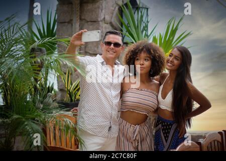 2 women and 1 man - group of friends taking a selfie while on vacation, Puerto Vallarta, Jalisco, Mexico Stock Photo