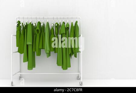 Hanger with green women's clothing against the background of a white wall. Monotonous green clothes. Creative conceptual illustration with copy space. Stock Photo