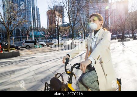 Wearing a mask of the young woman sharing bike riding Stock Photo