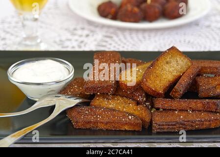 Garlic and black bread snacks with sour cream and greens sauce. perfect snacks with beer. Stock Photo