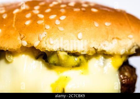 Close up of melted cheese in a homemade cheeseburger isolated on black plate. Stock Photo
