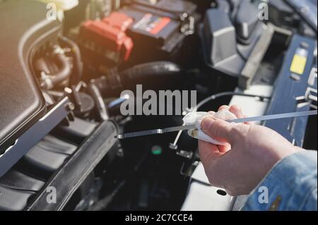 Checking oil level in car on engine background Stock Photo