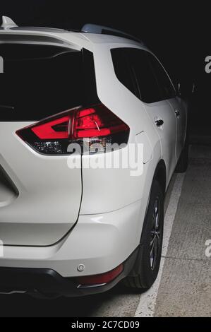 Back side view of white modern SUV car in black background Stock Photo