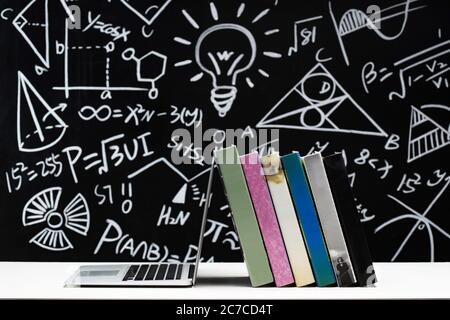 Tables in front of the blackboard drawing books and laptops Stock Photo