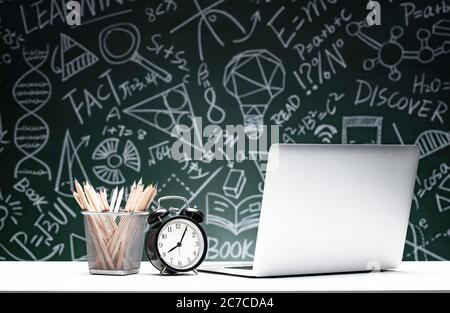 The blackboard drawing tables in front of the laptop and stationery Stock Photo