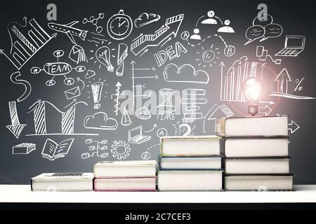 Tables in front of the blackboard drawing with textbooks from low to high Stock Photo