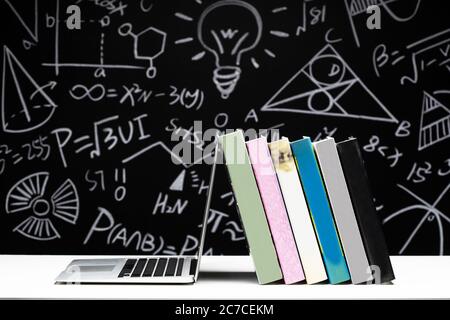 Tables in front of the blackboard drawing books and laptops Stock Photo