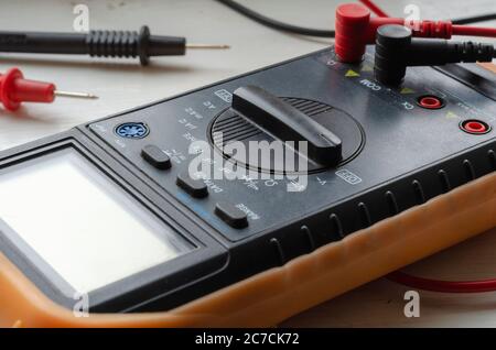 Close-up of a multimeter on a light background. Detailed shot of a measuring device. Qualified electrician services. Selective focus. Stock Photo