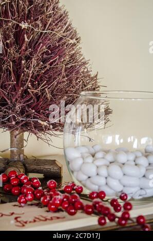 miniature decorative tree with red branches near huckleberry branch and fish tank with white stones Stock Photo