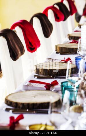 selective closeup shot of wooden disc decoration on a table with brown and red blankets on chairs Stock Photo
