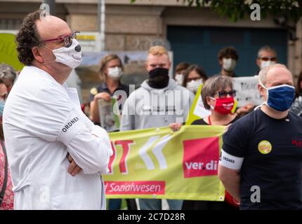 Hanover, Germany. 16th July, 2020. Frank Dressler, paediatric rheumatologist at the Hanover Medical School (MHH), is standing in front of the Lower Saxony State Chancellery during a rally. The employees of the MHH demanded better working conditions. Credit: Hilal Zcan/dpa/Alamy Live News Stock Photo