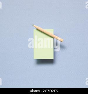 Green memo paper, sticky notes with colored pencil on blue background. top view, copy space Stock Photo