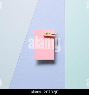 Pink memo paper, sticky notes with wooden clip on blue background. top view, copy space Stock Photo