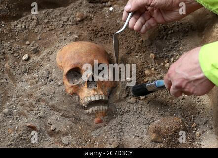 Archaeologists from the Trams to Newhaven project excavating human remains, which could date back as far as 1300, from the graves of South Leith Parish Church whose medieval graveyard extends beneath the road surface of Constitution Street, Leith. Stock Photo
