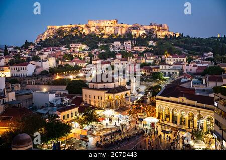 The historical Acropolis in Athens Greece is enthroned above the lively old town Plaka with scenic lighting at night. Stock Photo