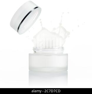 moisturizer cream splashing out of a small jar isolated on white Stock Photo