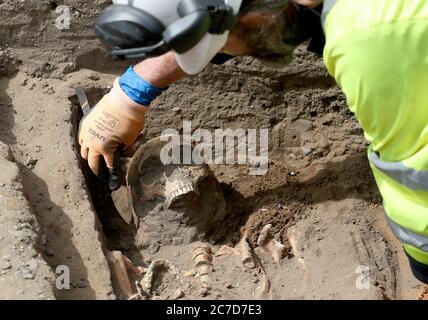 Archaeologists from the Trams to Newhaven project excavating human remains, which could date back as far as 1300, from the graves of South Leith Parish Church whose medieval graveyard extends beneath the road surface of Constitution Street, Leith. Stock Photo