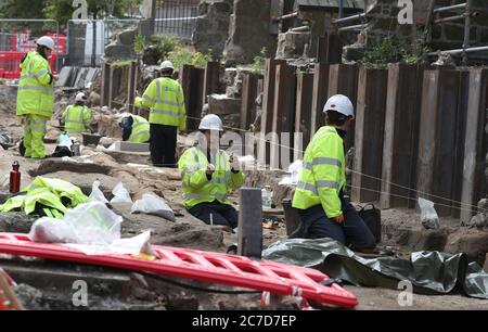 Archaeologists from the Trams to Newhaven project excavating human remains, which could date back as far as 1300, from the graves of South Leith Parish Church whose medieval graveyard extends beneath the road surface of Constitution Street, Leith. Stock Photo