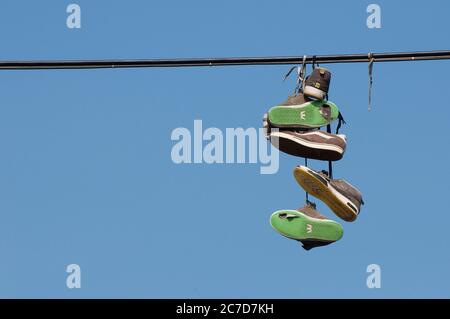 Shoes thrown over a wire hanging above a street in the city of Prague, Czech Republic. Stock Photo