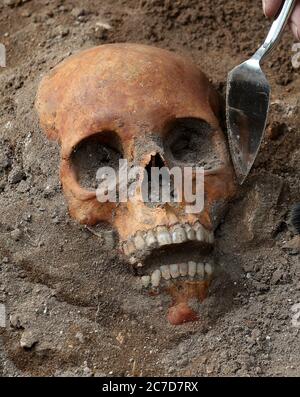 Archaeologists from the Trams to Newhaven project excavating human remains, which could date back as far as 1300, from the graves of South Leith Parish Church whose medieval graveyard extends beneath the road surface of Constitution Street, Leith. Stock Photo