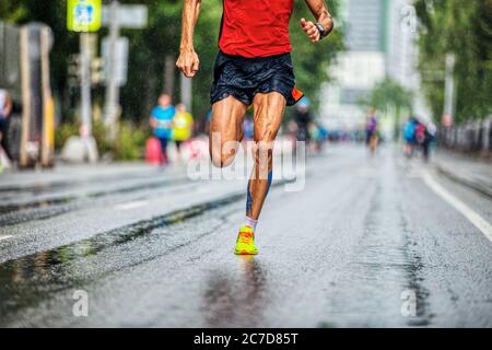 perfect legs runner athlete man run in rainy weather marathon Stock Photo